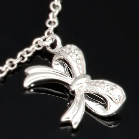 Stilvolle Halskette aus rhodiniertem 925er Silber mit eingearbeiteten Charms (Kreuz, Schleife und Anker) mit Zirkoniasteinen besetzt (Diamantimitationen), ca. 42-45 länge verstellbar
