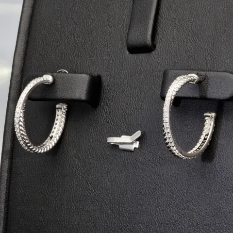 Glänzende Creolen / Ohrringe aus 925 Silber, rhodiniert und poliert, besetzt mit vielen, kleinen funkelnden Zirkonia-Steinen im Brillantschliff