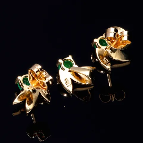 Originelles Set bestehend aus Ohrsteckern und Anhänger aus 750 / 18K Gold mit eingefassten Smaragden in exotischem Blatt - Design