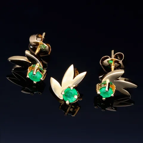 Originelles Set bestehend aus Ohrsteckern und Anhänger aus 750 / 18K Gold mit eingefassten Smaragden in exotischem Blatt - Design