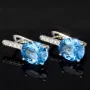 Edle Ohrringe / Ohrboutons aus 925 Sterling Silber bestückt mit 2 großen, leuchtenden blauen Zirkoniasteinen und 10 brillantgeschliffene, strahlende weiße Zirkonia