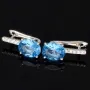 Edle Ohrringe / Ohrboutons aus 925 Sterling Silber bestückt mit 2 großen, leuchtenden blauen Zirkoniasteinen und 10 brillantgeschliffene, strahlende weiße Zirkonia