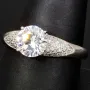 Edler Ring für Damen mit einem hochkarätigen Zirkonia im Brillantschliff (Diamantimitat) und vielen kleinen Zirkonia – 925er Sterling Silber, rhodiniert und poliert - RG ca. 63