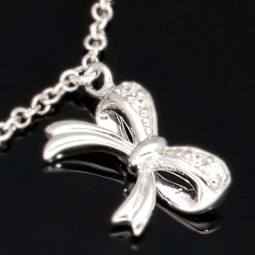 Stilvolle Halskette aus rhodiniertem 925er Silber mit eingearbeiteten Charms (Kreuz, Schleife und Anker) mit Zirkoniasteinen besetzt (Diamantimitationen), ca. 42-45 länge verstellbar