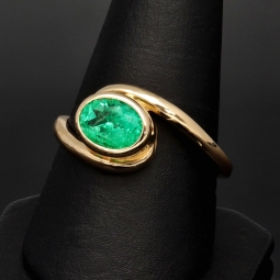 Prächtiger Ring für Damen aufwendig in Handarbeit gefertigt mit einem eingefassten, leuchtenden grasgrünen, kolumbianischen Smaragden in ovaler Form (ca. 1,06 ct.) in 18K / 750 Gelbgold - Ringgröße ca. 60-61