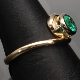 Prächtiger Ring für Damen aufwendig in Handarbeit gefertigt mit einem eingefassten, leuchtenden grasgrünen, kolumbianischen Smaragden in ovaler Form (ca. 1,06 ct.) in 18K / 750 Gelbgold - Ringgröße ca. 60-61