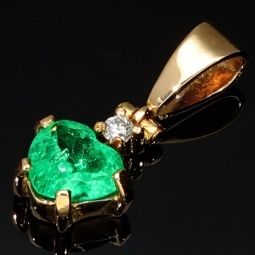 Kolumbianischer, leuchtend grasgrüner Anhänger aus 18K / 750 Gold bestückt mit einem Smaragd mit aufwendigem Herzschliff (ca. 0,74 ct.) und einem Brillanten (ca. 0,03 ct.) in edlen Krappen gefasst  - Handarbeit