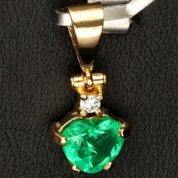 Kolumbianischer, leuchtend grasgrüner Anhänger aus 18K / 750 Gold bestückt mit einem Smaragd mit aufwendigem Herzschliff (ca. 0,74 ct.) und einem Brillanten (ca. 0,03 ct.) in edlen Krappen gefasst  - Handarbeit